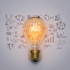 A glowing light bulb with various hand-drawn business and financial icons in the background, symbolizing innovation, strategic planning, and business growth.